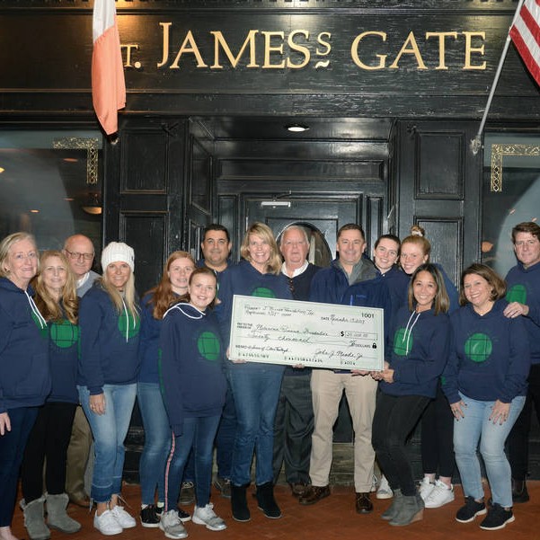 The Oysterfest volunteer team presents a check for $20,000 to the Melanoma Research Foundation